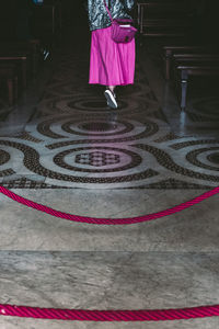 Rear view low section of woman walking on tiled floor