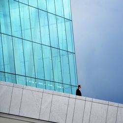 Man in modern building against sky