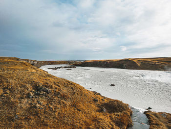 Grass covered hills and bright blue river