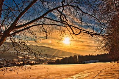 Scenic view of snow covered landscape against sky during sunset