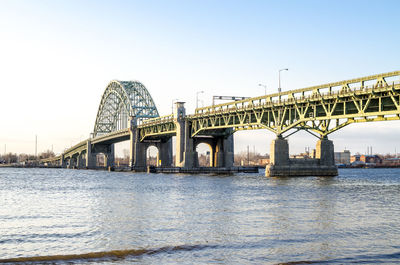 Low angle view of bridge over river against sky