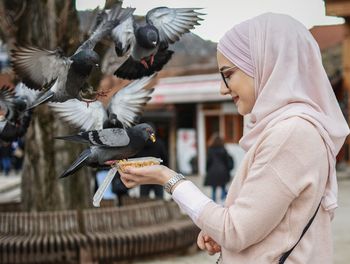 Side view of man feeding birds