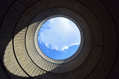 Directly below shot of cloudy sky seen through ceiling hole
