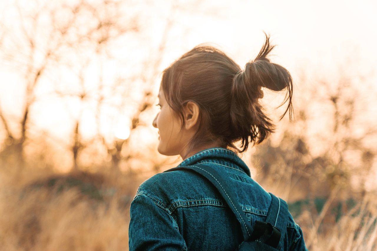 one person, real people, focus on foreground, leisure activity, headshot, rear view, lifestyles, nature, portrait, plant, women, casual clothing, young adult, hair bun, hairstyle, hair, day, sky, land, outdoors