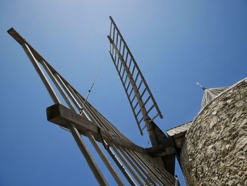 Low angle view of traditional windmill against clear blue sky