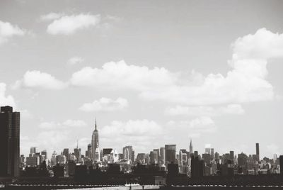 View of cityscape against cloudy sky