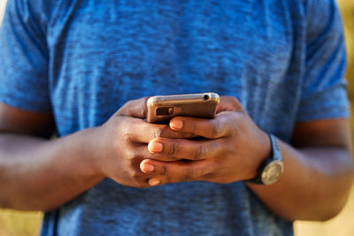 Midsection of man using mobile phone