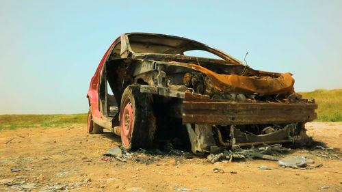 Abandoned truck on field against clear sky