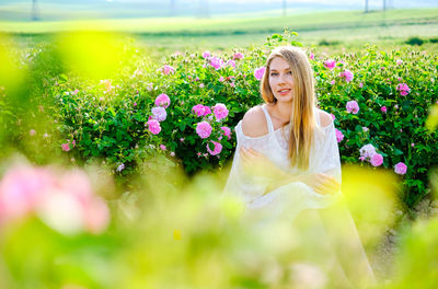 Portrait of woman with pink flowers in garden
