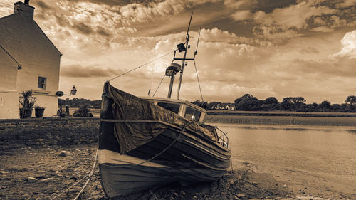 Boats moored on beach against sky