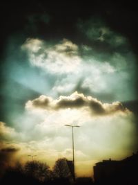 Silhouette of trees against cloudy sky