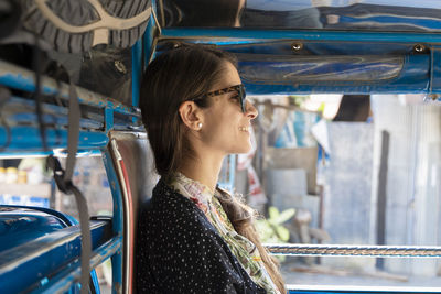 Side view of smiling woman traveling in vehicle