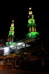 Low angle view of illuminated building against sky at night