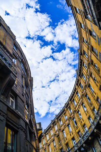 Low angle view of buildings against cloudy sky