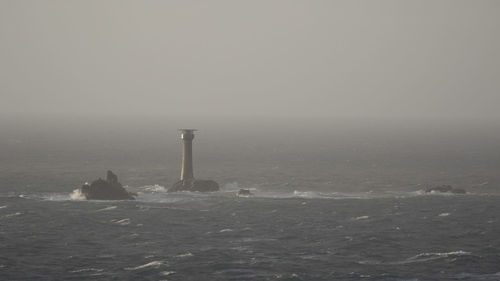 View of lighthouse by sea against sky