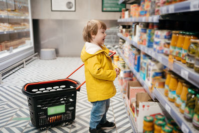 Rear view of boy standing in supermarket