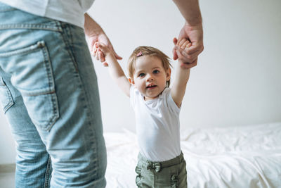 Happy father young man and baby girl little daughter having fun in children room at home