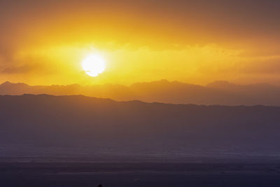 Scenic view of silhouette mountains against romantic sky at sunset