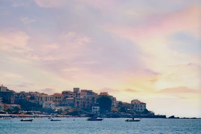 View of sea and buildings against sky during sunset