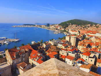 High angle view of townscape by sea against sky