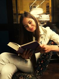 Young woman sitting on book