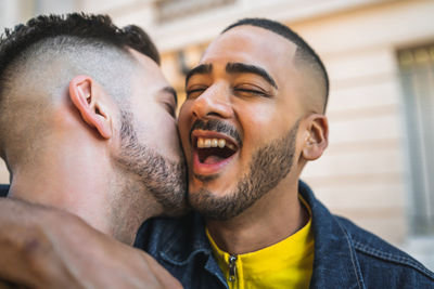 Close-up of man romancing with cheerful boyfriend in city