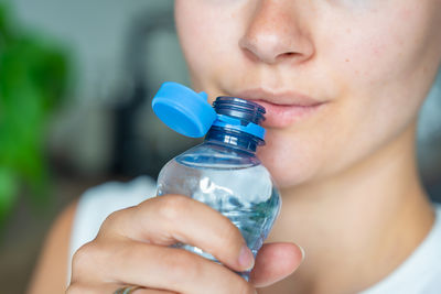 Cropped hand of woman holding bottle