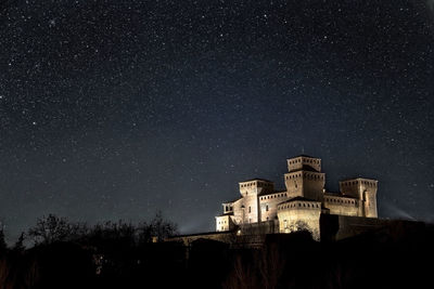 Low angle view of illuminated castle against sky at night, torrechiara parma italy 