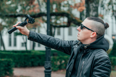 Young man photographing with camera