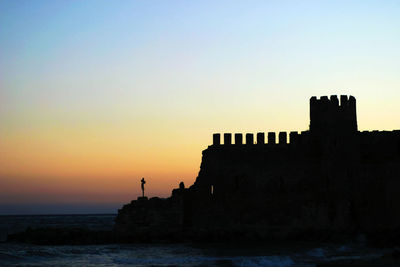 Silhouette of building against sky during sunset