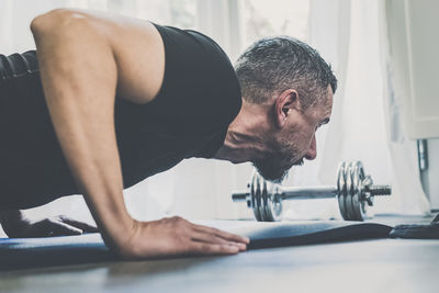 Sporty man working out and trains at home. fit male doing exercise. wellness, health, sport concept