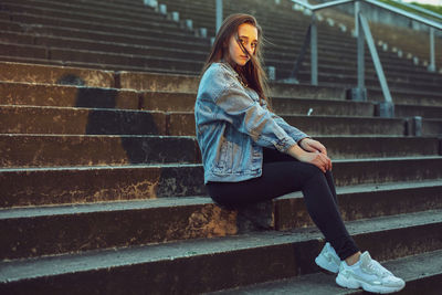 Portrait of young woman sitting on staircase