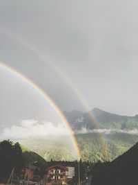 Rainbow over landscape against sky