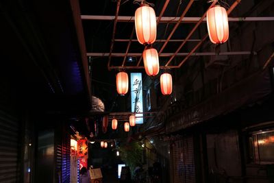 Low angle view of illuminated lanterns in city at night