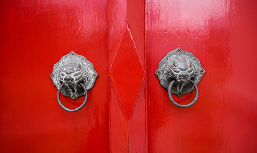 Metallic knockers on red door