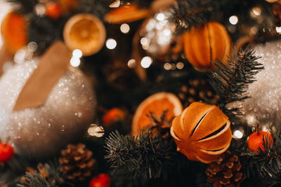 Creative christmas tree decorated with dry oranges, pine cones and mandarins. cozy details. winter