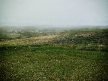 Scenic view of field against sky during foggy weather