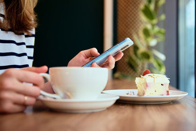 Woman have breakfast at cafe, use smartphone at cafe