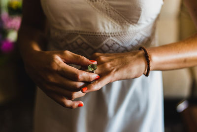 Midsection of bride wearing ring standing at home