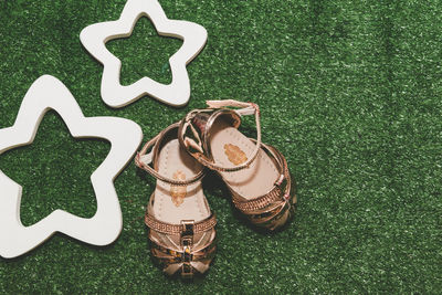 High angle view of sandals by star shape on grass