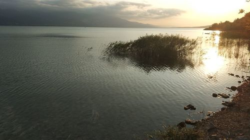 Scenic view of lake against sky during sunset