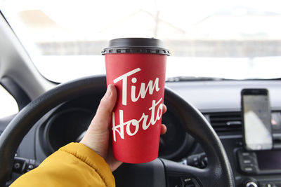 Close-up of hand holding red car