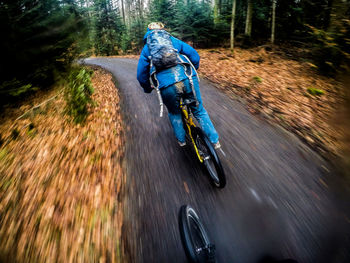 Blurred motion of person riding bicycle on road