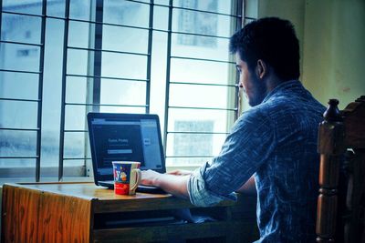 Side view of man working at office