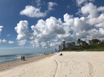 Panoramic view of people on beach against sky