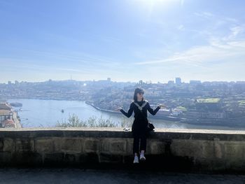 Rear view of woman standing against sky