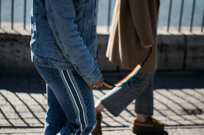 Midsection of people holding colorful textile while walking outdoors