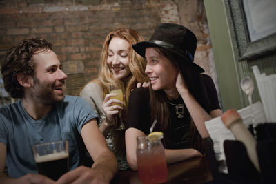 Happy young friends enjoying drinks at a bar