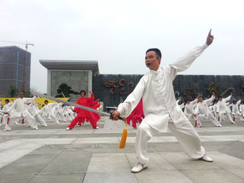 Group of people dancing against sky