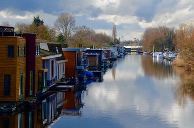 Houses by river against sky